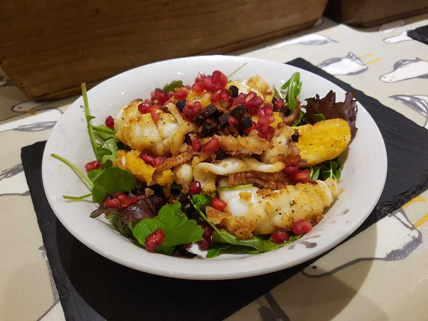 Pan Fried Squid with Liquorice and Pomegranate Seeds on Herb Salad.