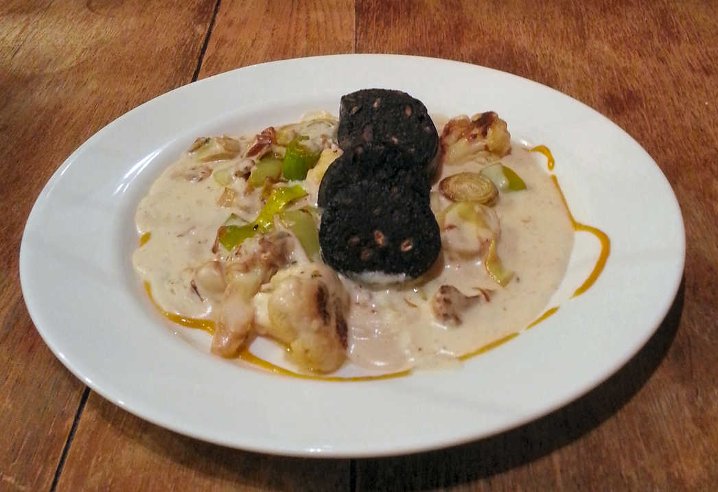 Vegetables in white sauce with black pudding.